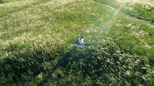 Girl meditates on a beautiful green meadow