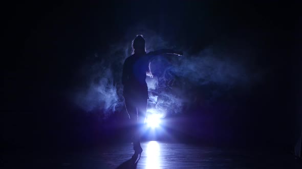 Girl Is Dancing in Smoke Latin Dance. Dark Background, Blue Backlight