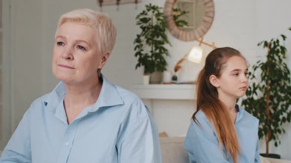 Full Length Depressed Old Senior Grandma Sit on Sofa Separately From Stressed Offended Small