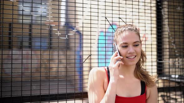 Smiling sportswoman phoning at basketball court