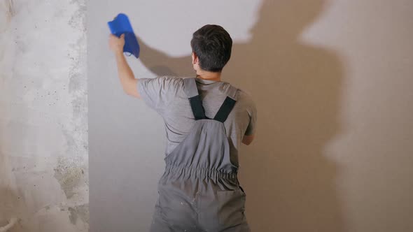 Man Applying Wallpaper on Wall