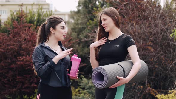 Pretty Sporty Ladies with the Sports Equipment Are Talking Outside