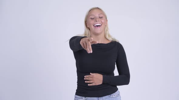Young Happy Blonde Woman Laughing and Pointing at Camera