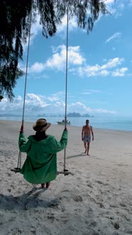 Couple Men and Woman on the Beach in Thailand with Swing on the Beach of Naka Island Phuket Thailand