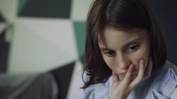 Portrait Serious Schoolgirl Looking Down Sitting Corridor