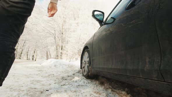 Female Person Closes Black Car Door In Winter