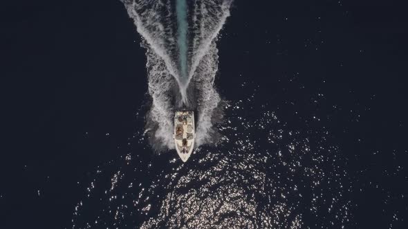 Aerial view of small speed boat with trailing wake on sea.