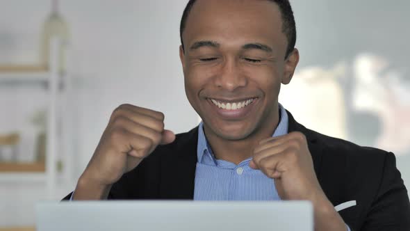 Close Up of Casual Afro-American Businessman Celebrating Success, Working on Laptop