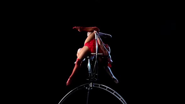 Two Gymnasts Performs a Trick on the Aerial Hoop Metal Construction. Black Background. Slow Motion