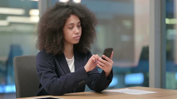 Attractive African Businesswoman Using Smartphone at Work