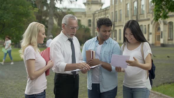 Male Teacher Giving Tests to Multi-Ethnic Students and Explaining Results