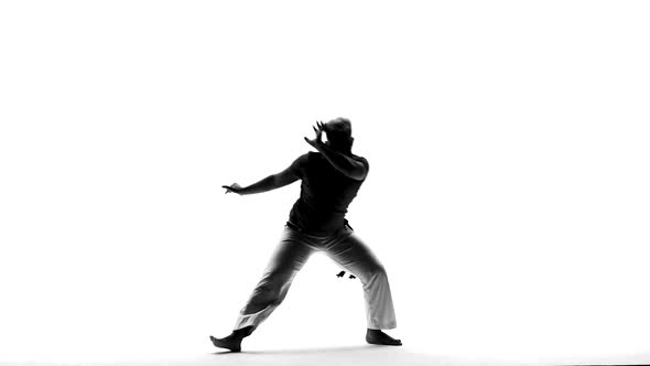 Silhouettes of Man Practicing Capoeira in White Background of Studio. Afro-Brazilian Martial Art