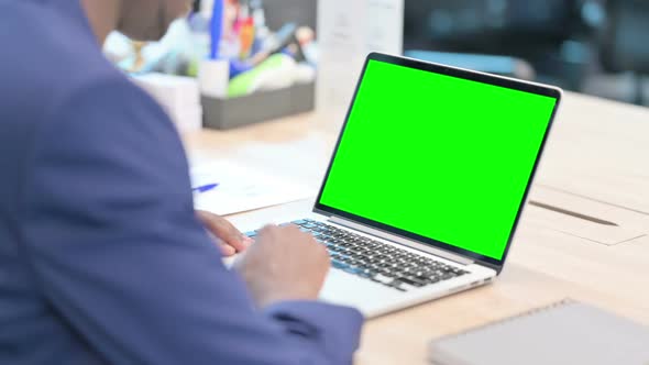 Rear View of Young Businessman Using Laptop with Chroma Screen