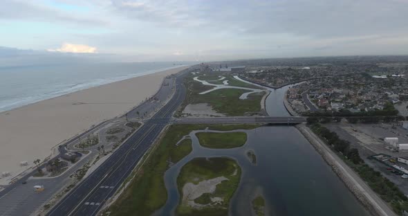 A drone flies high above the beach coast revealing ocean front luxury homes in Orange County.