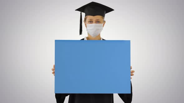 Graduate Student Girl in Protection Mask Holding Blank Board on Gradient Background.