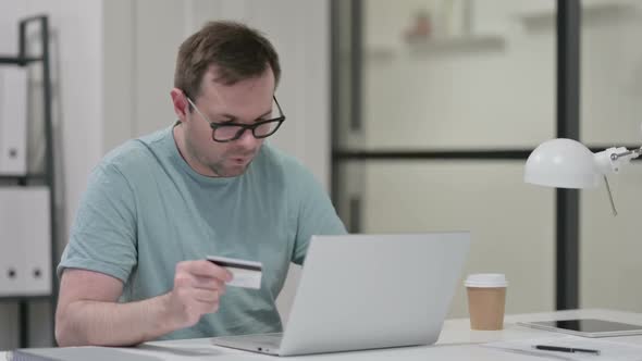 Successful Online Payment on Laptop By Young Man