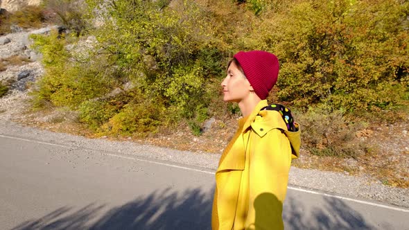 Free Happy Young Hiker Woman in Yellow Coat Enjoying Calm Sunny Day in the Nature Breathing Fresh