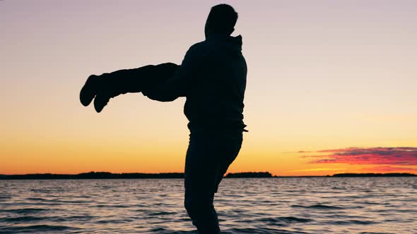 A Man is Spinning His Child Around at the Shore