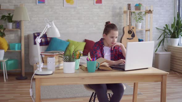 Teen Uses Laptop and Does Homework