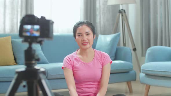 Asian Woman Blogger In Sportswear Shoots Video On Camera As She Does Exercises At Home