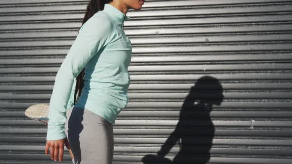 African american woman in sportswear stretching in street before exercising