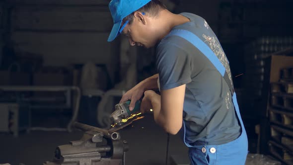 man works with a circular saw. Sparks fly from the hot metal.