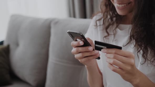 A Credit Card and Smartphone in Female Hands