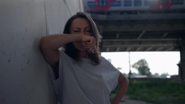 a Female Portrait Against the Background of a Railway Bridge with Passing Vehicles is Out of Focus