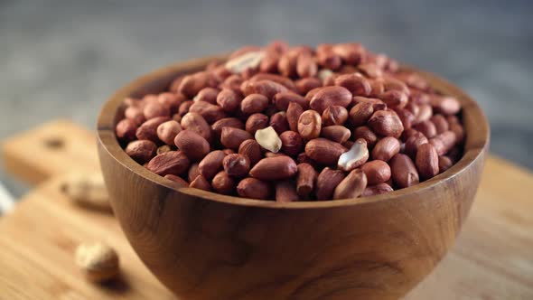 Raw Peanuts in small wooden bowl on natural gray rustic desk Video 4k