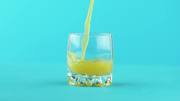 Slow Motion Close-up Shot of Fruit Orange Multifruit Juice Cold Beverage Drink Pooring Into Small