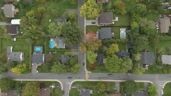 Drone slowly drifting while gliding over streets and houses in suburban city