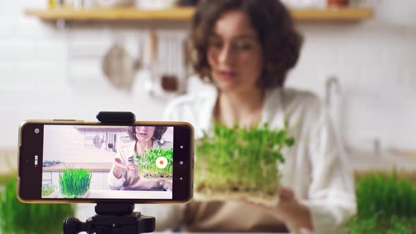 Beautiful Young Girl Recording Vlog About Healthy Nutritional Supplements While Standing In Kitchen