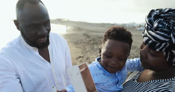 African parents and little son having fun on the beach - Family people and love concept