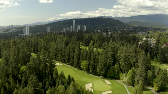 Aerial dolly right of golf course with pine trees on Tri-Cities area, Vancouver, British Columbia, C