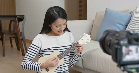 Woman teach the ukulele and take video on camera for social media