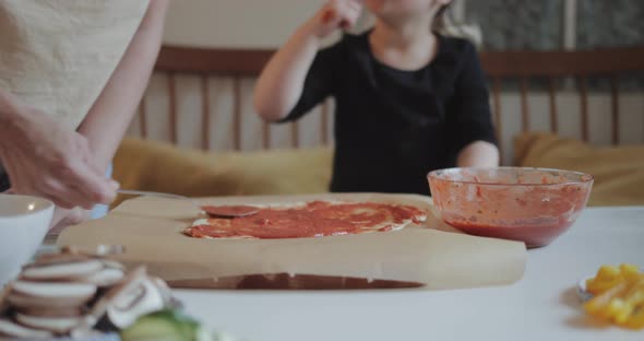 Mother and daughter making pizza at home