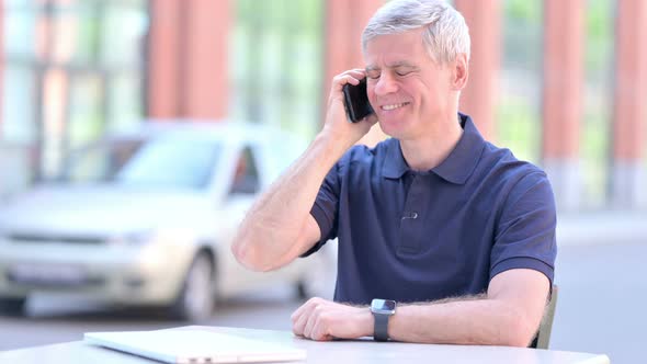 Outdoor Cheerful Middle Aged Businessman Talking on Smartphone