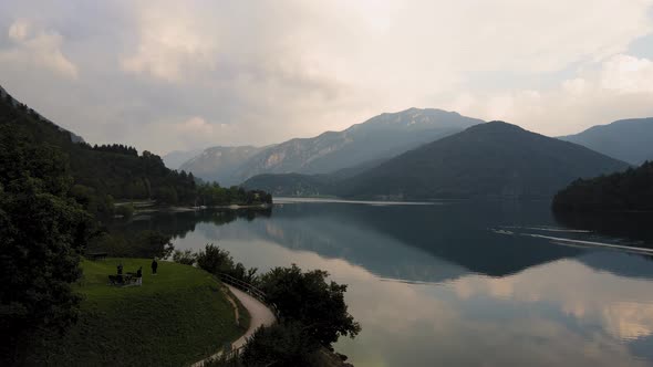 Aerial view over the Ledro lake, Trentino, Italy. Drone over the lake with reflected sky in the wate