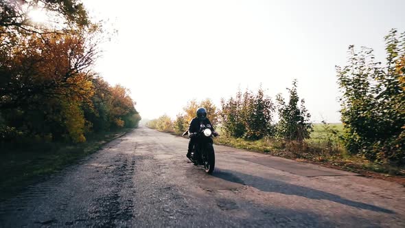 Front View Man in Helmet Riding Motorcycle on a Country Road