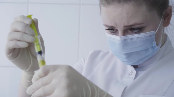 Close-up Face of Focused Caucasian Lab Assistant Processing Blood Sample in Laboratory. Portrait of