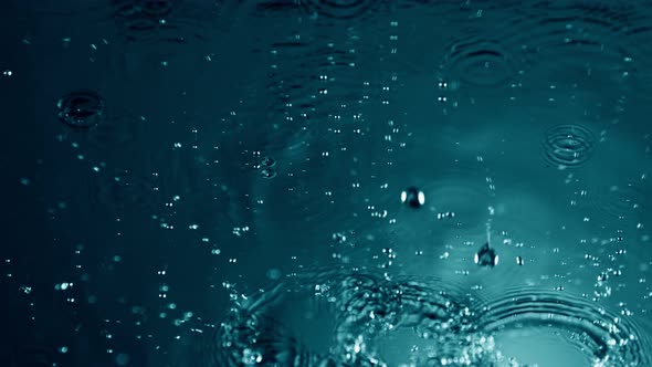 Super Slow Motion Shot of Many Water Drops Falling and Splashing on Surface at 1000Fps alt