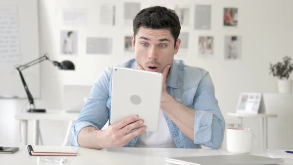 Casual Young Man in Shock while Using Tablet