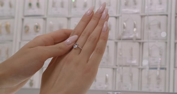 А woman tries on a diamond ring. Closeup of beautiful hand with ring