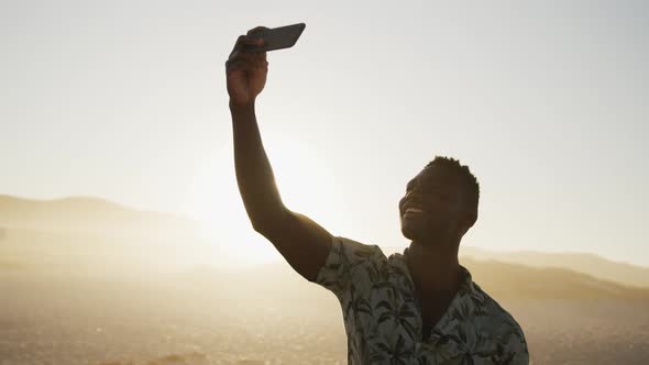 African American man taking a selfie at beach