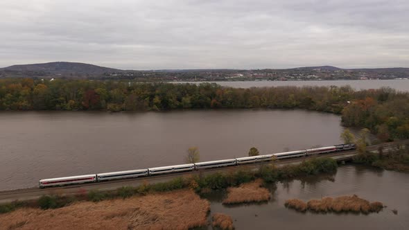 A drone shot over a marsh, surrounded by the fall foliage on a cloudy day, in upstate NY. The camera