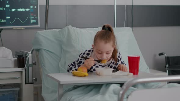 Portrait of Hospitalized Little Child Resting in Bed Eating Healthy Food Meal During Recovery