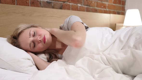 Tired Woman with Pain in Neck Lying on Side in Bed
