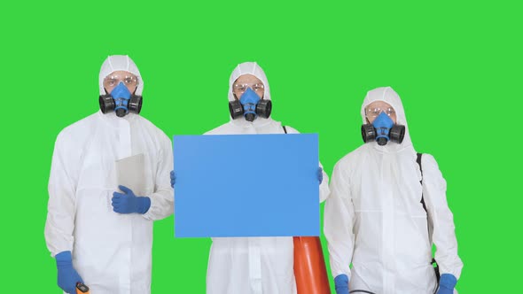 Group of Epidemiologists in Protective Uniform Holding Blank Placard on a Green Screen, Chroma Key