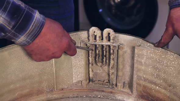 The Hands of the Master Clean the Heating Element From Plaque