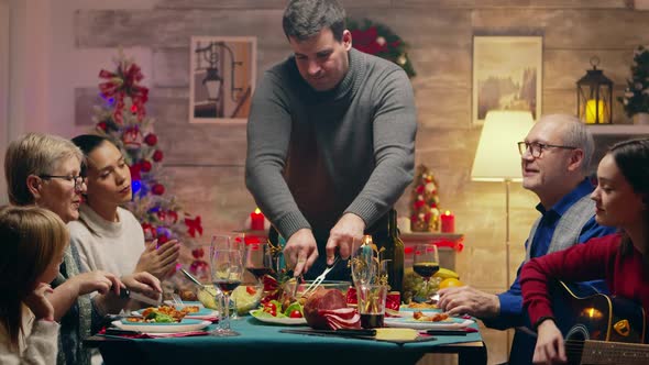 Adult Man Slicing the Chicken for Christmas Celebration